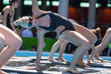 Rimini, İtalya - Mayıs 2019: Açık Yüzme Havuzu 'nda Yüzen Spor Mat Üzerine Egzersiz Yapan Kız