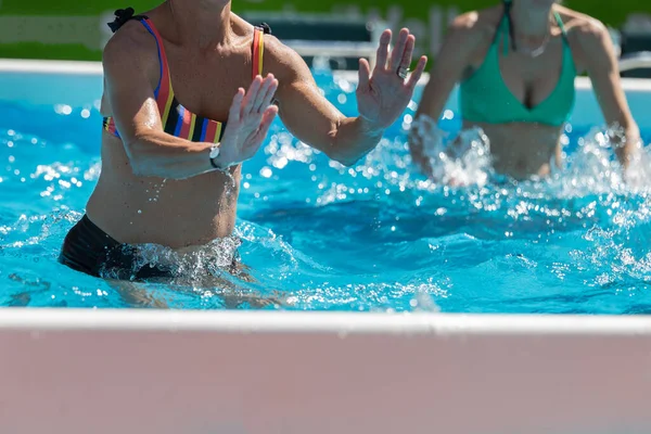 Menschen machen Wassergymnastik im Freien in einem Schwimmbad — Stockfoto