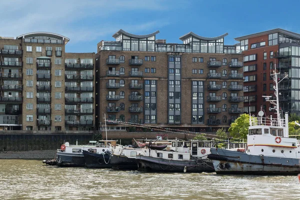Hus och vattenskotrar längs floden Themsen nära Canary Wharf — Stockfoto