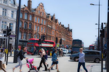 Camden High Caddesi 'nin yanındaki Camden Meydanı' nda insanlar ve kırmızı çift katlı otobüsler var..