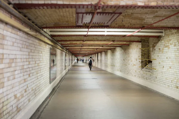 Subway Underpass: Long Tunnel with People in the Way.