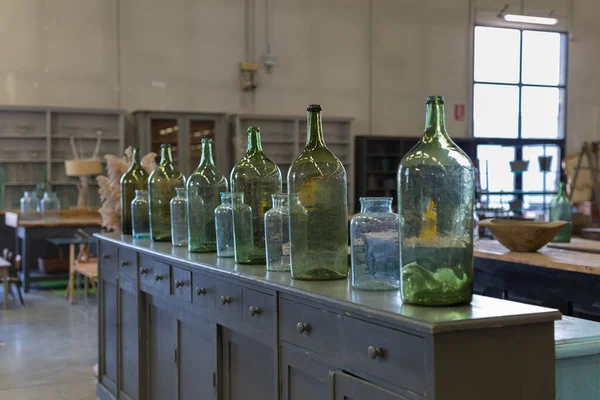 Sechs Grüne Leere Und Schmutzige Glasflaschen Über Einer Antiken Holzkommode — Stockfoto