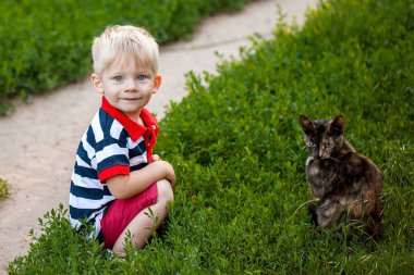 siyah bir kedi ile oynarken küçük çocuk