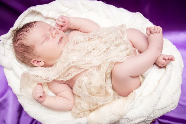 Новонароджена дитина спить, загорнута в легку тканину — стокове фото