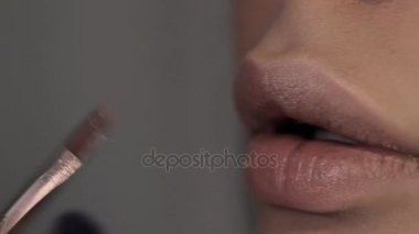 Güzel kız, dolgun dudaklar dudak makyaj sanatçısı boyalar
