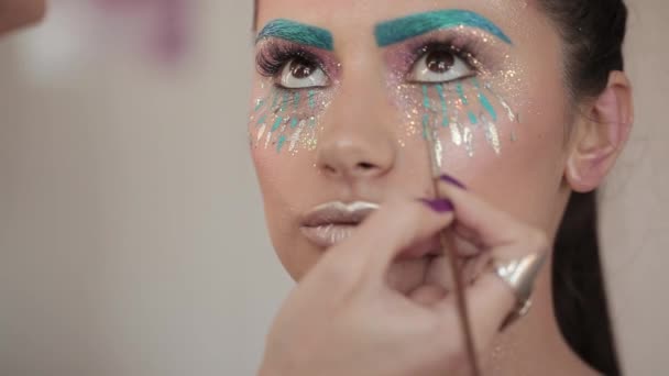 Make-up artist maluje usta na piękną dziewczynę, pulchne usta — Wideo stockowe