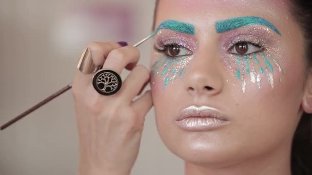 Make-up artist maluje usta na piękną dziewczynę, pulchne usta — Wideo stockowe