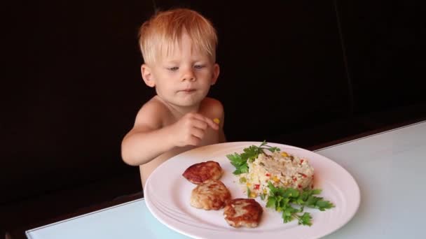 En liten pojke äter mat på ett kafé, närbild — Stockvideo