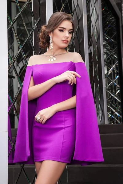 Belle jeune fille est un modèle dans une robe violette sur un backgroun — Photo