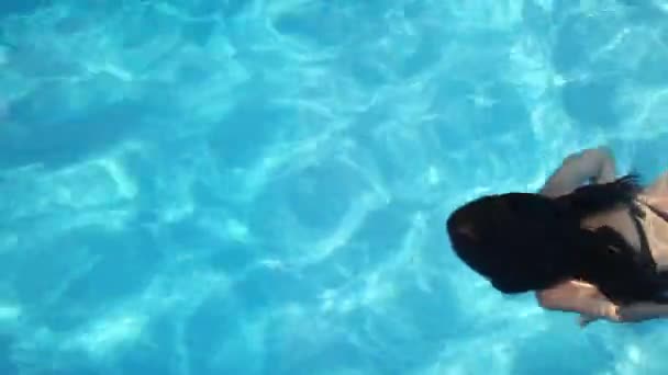 Girl swims under the water in the pool — Stock Video