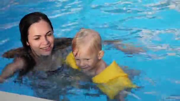 Дитина купається з матір'ю в басейні, сім'я — стокове відео