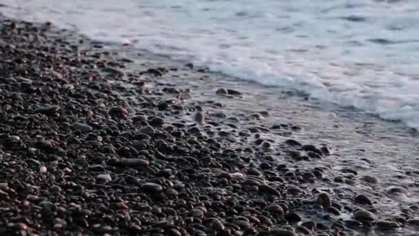 Frenado de mar contra piedras y guijarros en una playa, olas de agua pura — Vídeo de stock