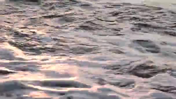 Freinage en mer contre des pierres et des cailloux sur une plage, vagues d'eau pure 