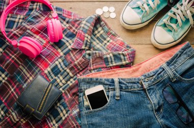 Aksesuar kot akıllı aygıtlar kulaklık cüzdan spor ayakkabıları bir ahşap zemin üzerinde