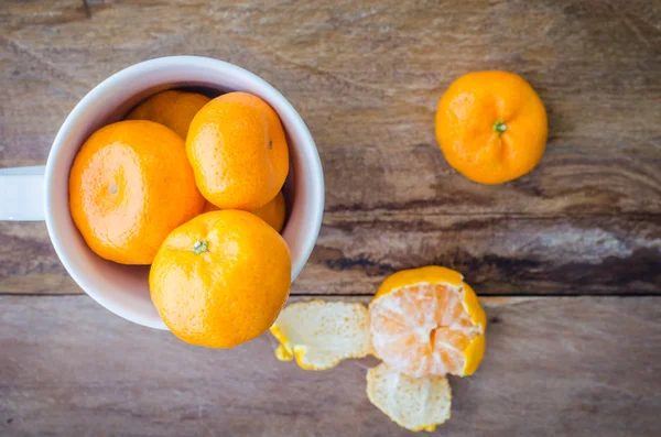 Orange in einer Glasschale auf einem Holzboden. — Stockfoto