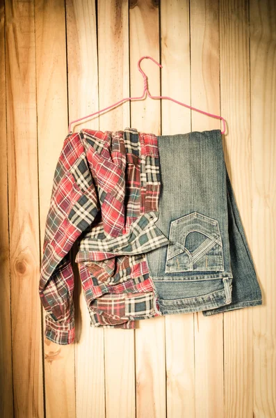 Traje colgando sobre fondo de pared de madera - naturaleza muerta tono vintage — Foto de Stock