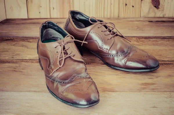 Pánské hnědé boty na dřevěné podlaze. — Stock fotografie