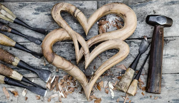La madera del corazón se coloca en un piso de madera y una pasta de madera tallada . — Foto de Stock