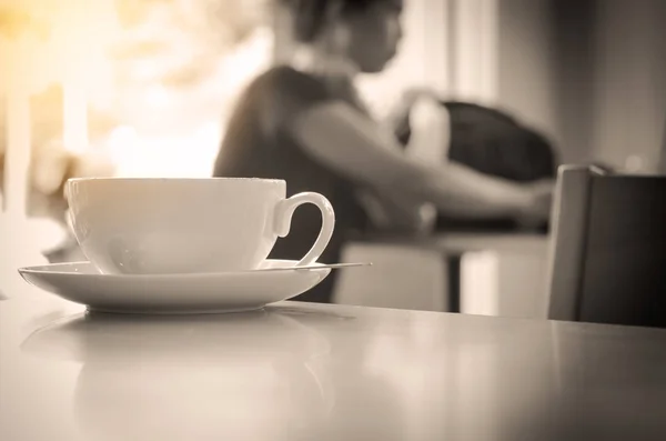 Primo piano della tazza di caffè sul tavolo in caffetteria - tono bianco e nero — Foto Stock