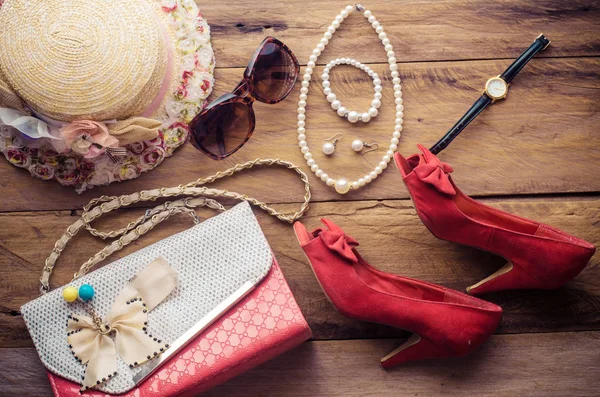 Accesorios para la muchacha adolescente en sus vacaciones, sombrero, elegante para las gafas de sol del verano, bolso de cuero, zapatos y traje en piso de madera . — Foto de Stock