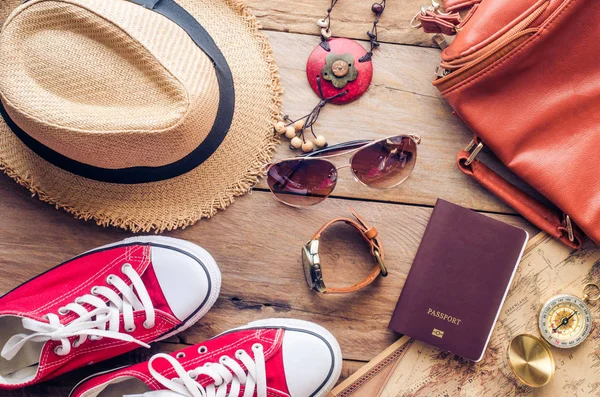 Accesorios para adolescente en sus vacaciones. Sombrero de paja, gafas de sol con estilo, bolso de cuero marrón, zapatos rojos y traje en piso de madera . — Foto de Stock
