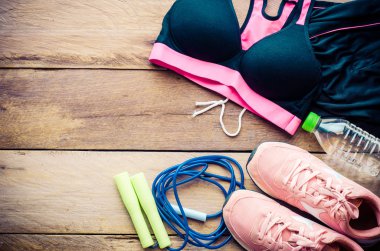 Ahşap arka planda egzersiz ekipmanları ile fitness kavramı.