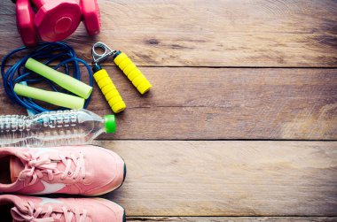 Ahşap arka planda egzersiz ekipmanları ile fitness kavramı.