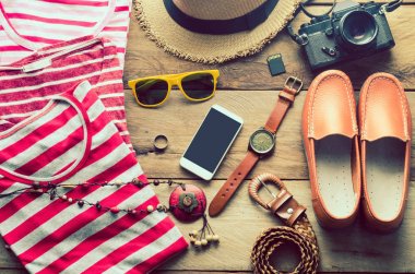 Seyahat için giyim, beyaz bir ahşap zemin üzerinde yer.