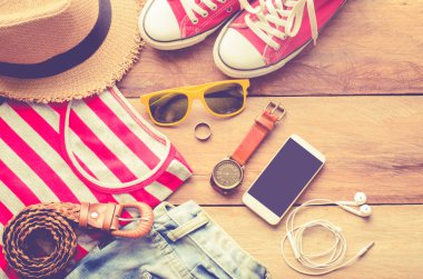 Seyahat için giyim, beyaz bir ahşap zemin üzerinde yer.