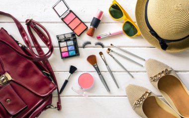 Beyaz ahşap zemin üzerinde kadınlar için giyim ve kozmetik