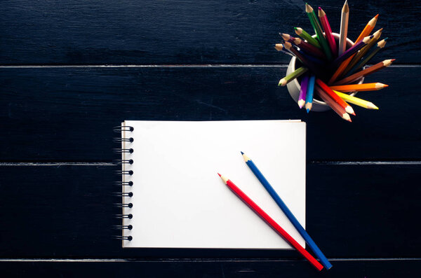 notebook pencill and cup of coffee in wood table