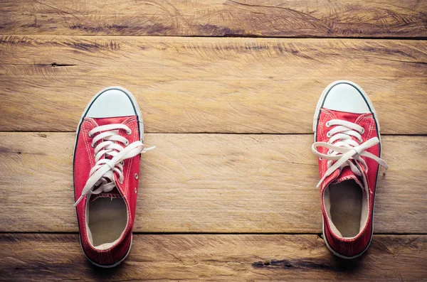Zapatillas rojas, poner en el suelo de madera . — Foto de Stock