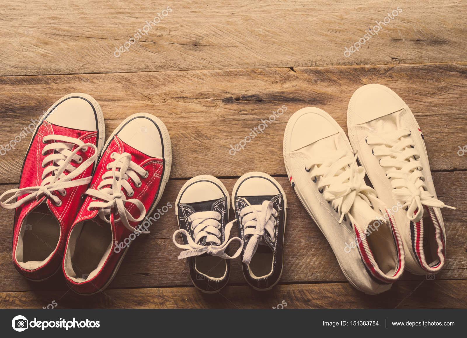 Drei Paar Schuhe auf dem Holzboden der Familie lag, pare Paare Der Bunten Stiefel Auf Dem Boden Stockfoto Bild von