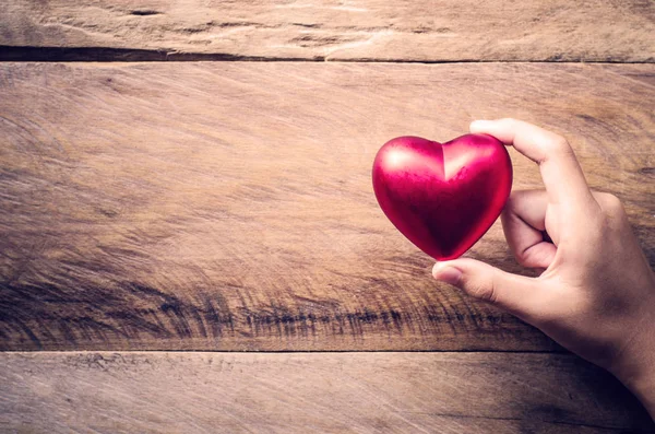 Mani femminile dando cuore rosso — Foto Stock