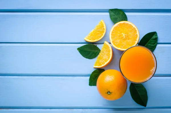 Naranjas frescas y jugo en la madera azul — Foto de Stock