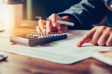 İşadamı bir hesap makinesi ve dizüstü bilgisayar ile çalışıyoruz. ofiste 