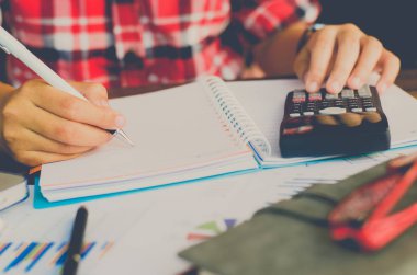 İşadamı bir hesap makinesi ve dizüstü bilgisayar ile çalışıyoruz. ofiste 