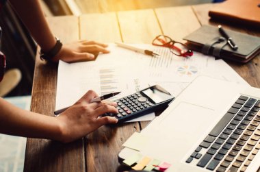 İşadamı bir hesap makinesi ve dizüstü bilgisayar ile çalışıyoruz. ofiste 