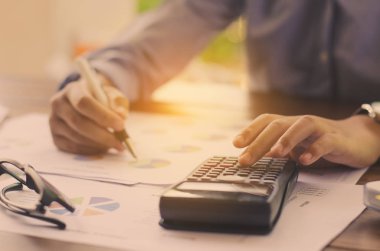 İşadamı bir hesap makinesi ve dizüstü bilgisayar ile çalışıyoruz. ofiste 