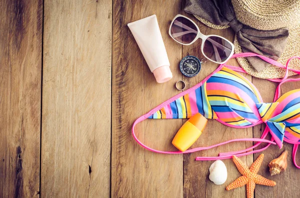 Szépség színes bikini és kiegészítők, fa padló, utazás — Stock Fotó
