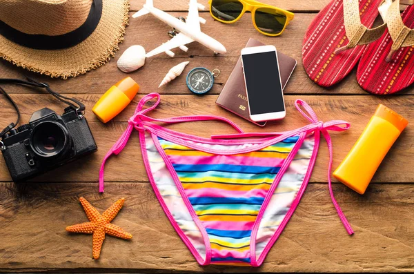 Bellezza bikini colorato e accessori sul pavimento in legno per il viaggio — Foto Stock