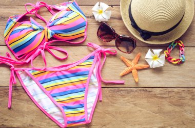 Güzellik renkli bikini ve aksesuarları seyahat için ahşap zemin üzerinde 