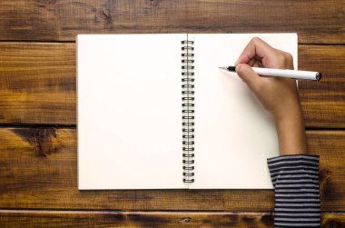 El ahşap zemin üzerinde bir defter yazıyoruz