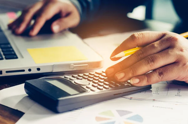 İşadamı bir hesap makinesi ve dizüstü bilgisayar ile çalışıyoruz. ofiste 