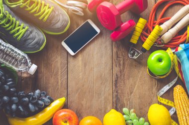 Ahşap arka planda egzersiz ekipmanları ile fitness kavramı.