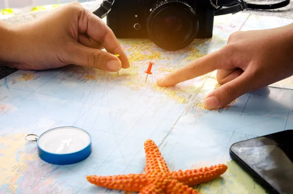 Tourists are planning a trip on a map and mark a place of intere — Stock Photo, Image