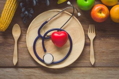 Ahşap arka plan üzerinde sağlıklı kavramı, meyve ve kulak doktor