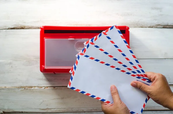 Kädet hakevat kirjekuoren postilaatikosta. . — kuvapankkivalokuva