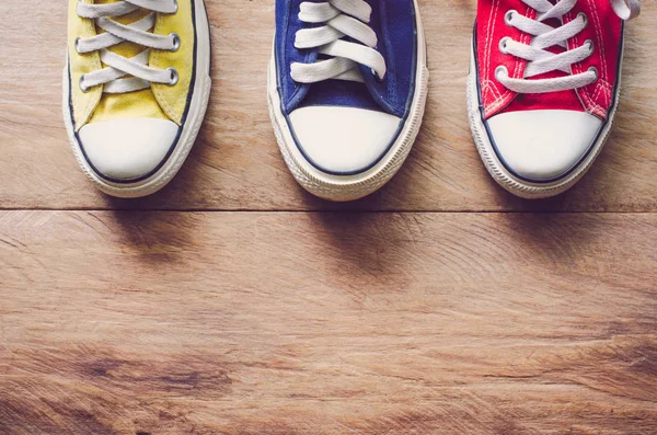 Multi Color sneakers on wood background — Stock Photo, Image