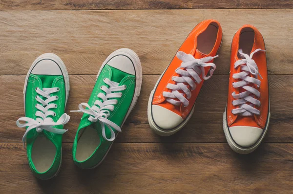 Red and Green sneakers on wooden floors - lifestyle — Stock Photo, Image